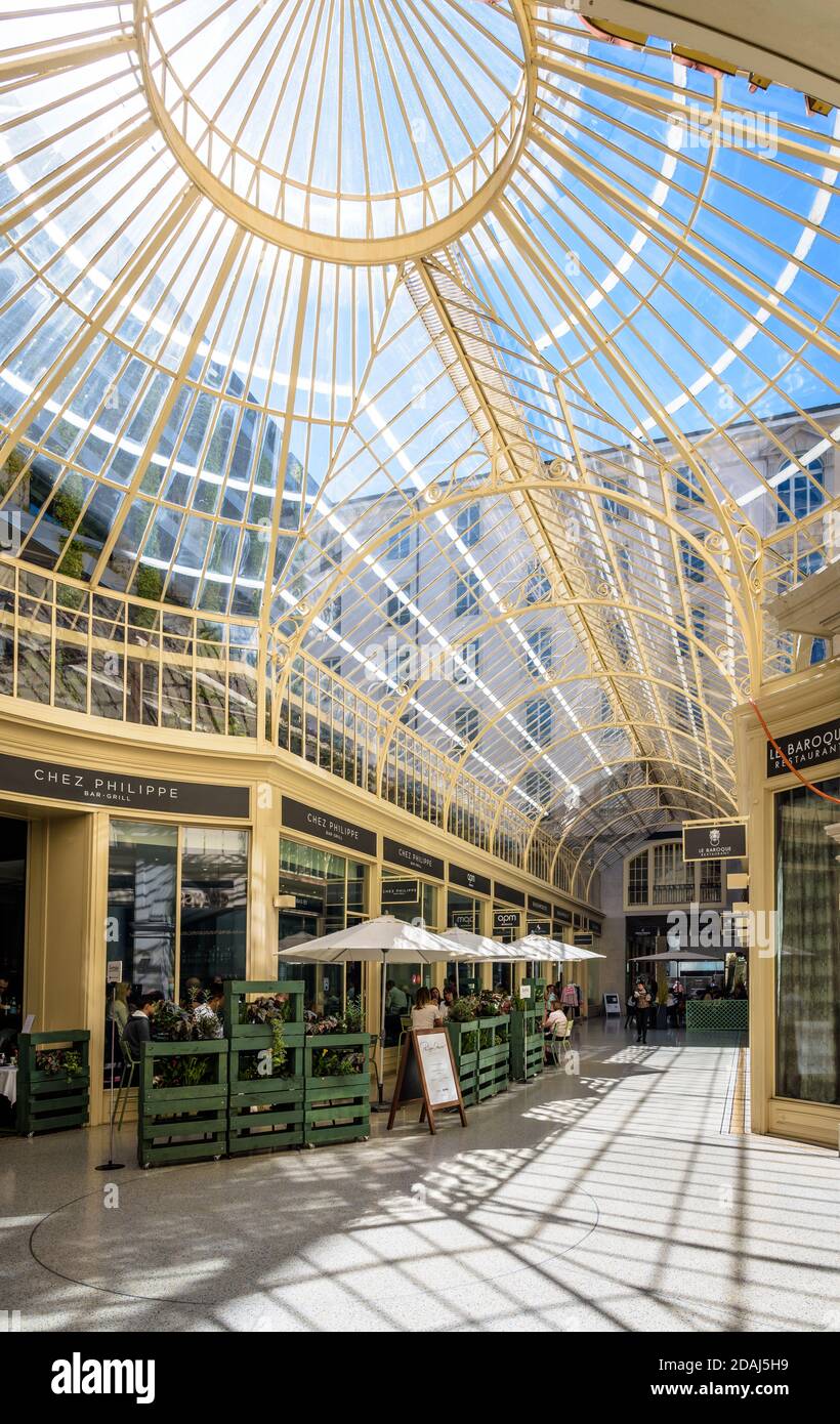 Restaurants et magasins dans le passage des Lions, passage piéton couvert d'un toit en verre dans le centre-ville de Genève. Banque D'Images
