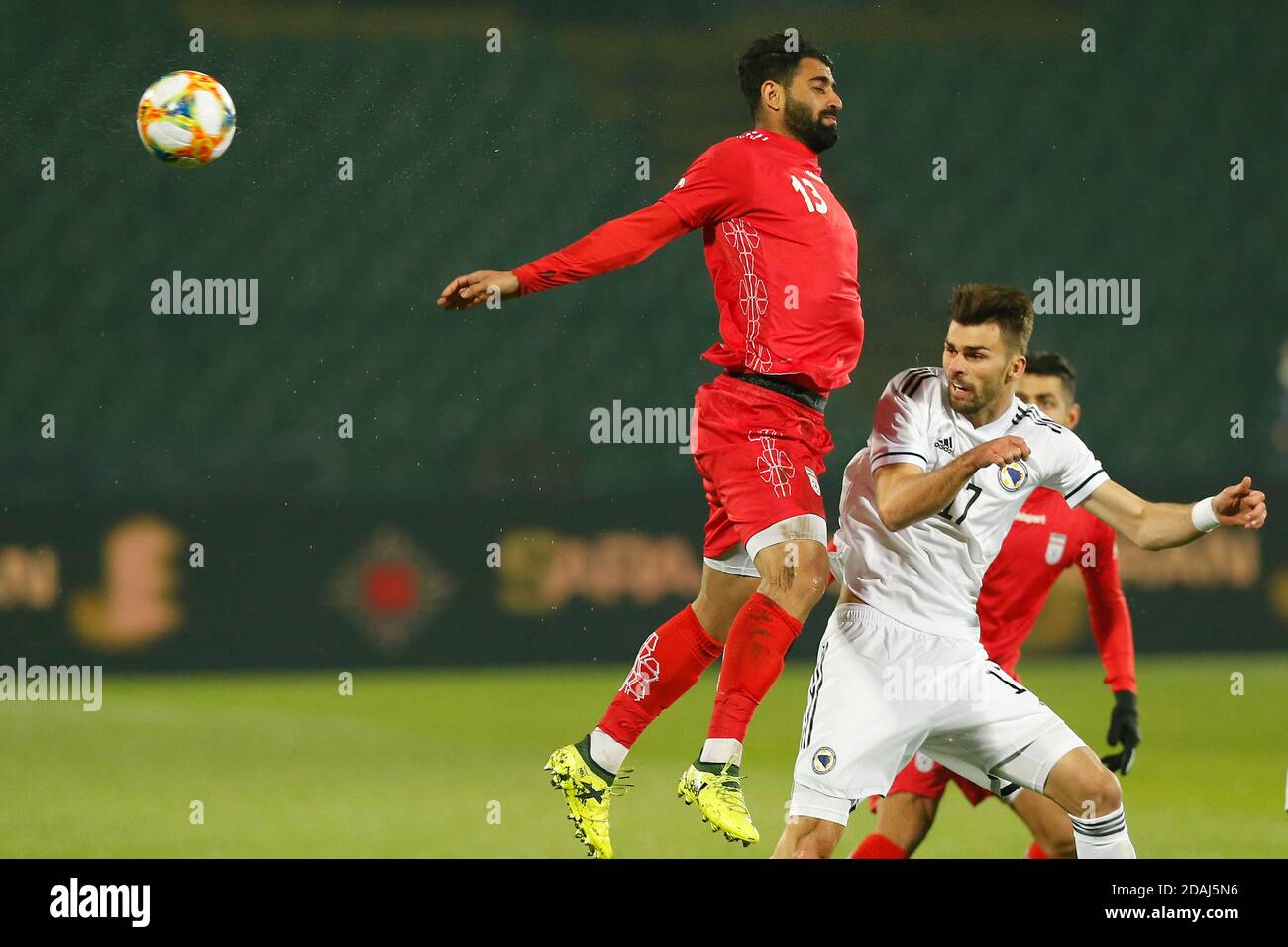 Joueur iranien Hossein Kanaanizadegan, rouge robe défi ballon avec Bosniaque Amar Rahmanovic pendant un match de football amical Bosnie contre Iran Sarajevo Banque D'Images