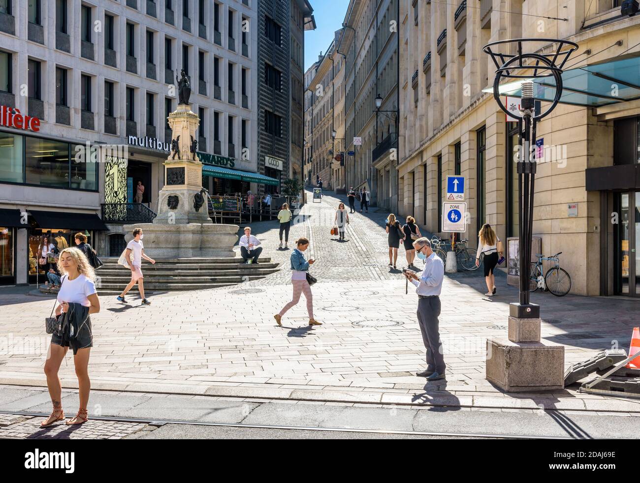 Les gens qui marchent le long de la fontaine de l'escalade à Genève, un mémorial à la victoire de la République protestante sur le duché catholique de Savoie. Banque D'Images