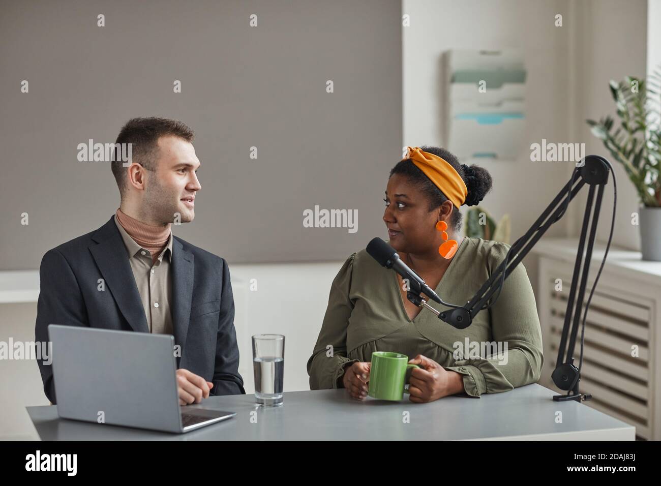Deux personnes en voyage d'affaires assises à la table avec un ordinateur portable et et avoir un entretien à la radio Banque D'Images