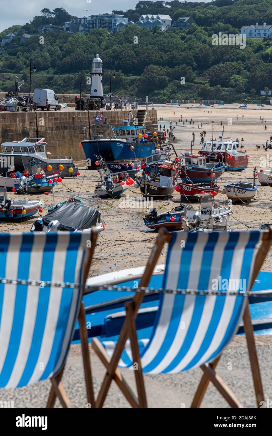 Transats en face des bateaux à marée basse, port de St Ives, Cornwall, Royaume-Uni Banque D'Images