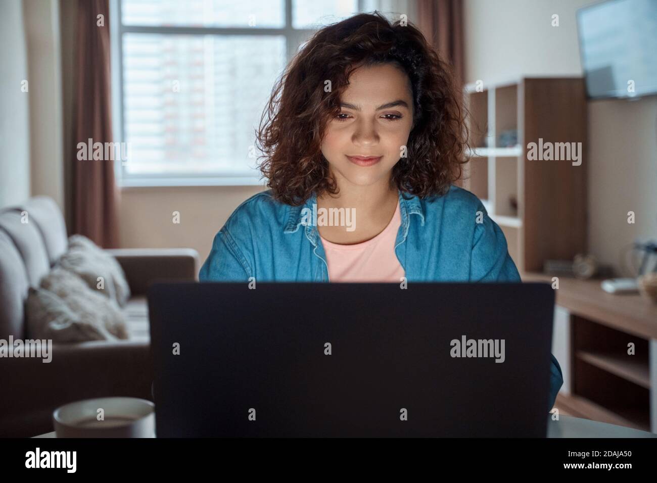 Photo horizontale de jeune femme indépendante travaillant en ligne sur ordinateur portable. Banque D'Images