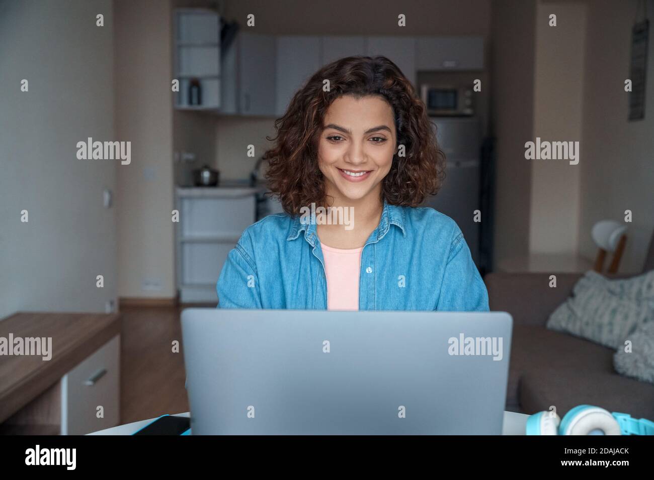 Jeune femme latine souriante freelance travaillant en ligne sur ordinateur portable. Banque D'Images