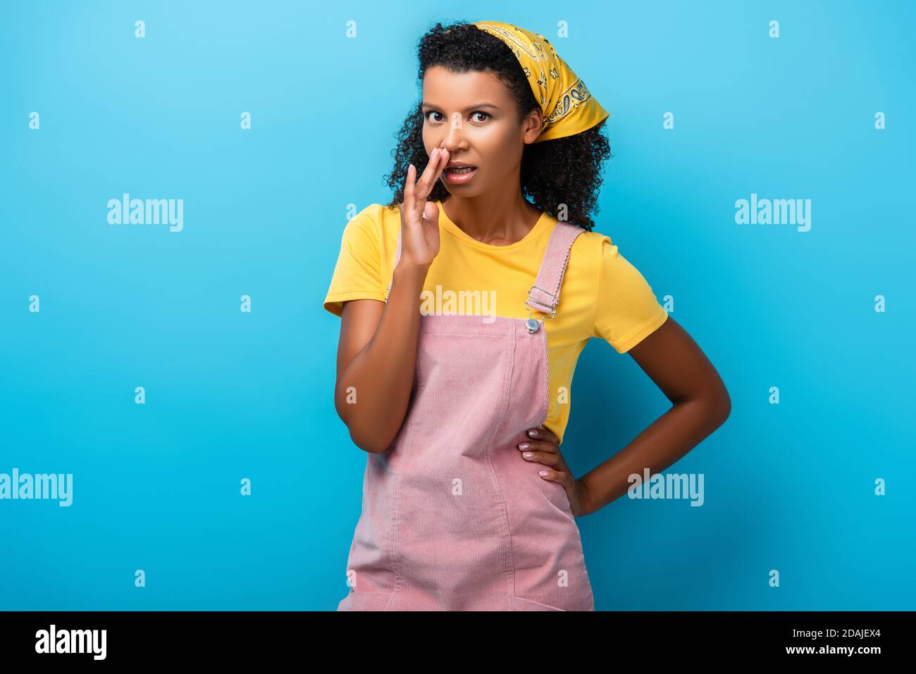 femme afro-américaine mauriquement debout avec la main sur la hanche et persiflage bleu Banque D'Images