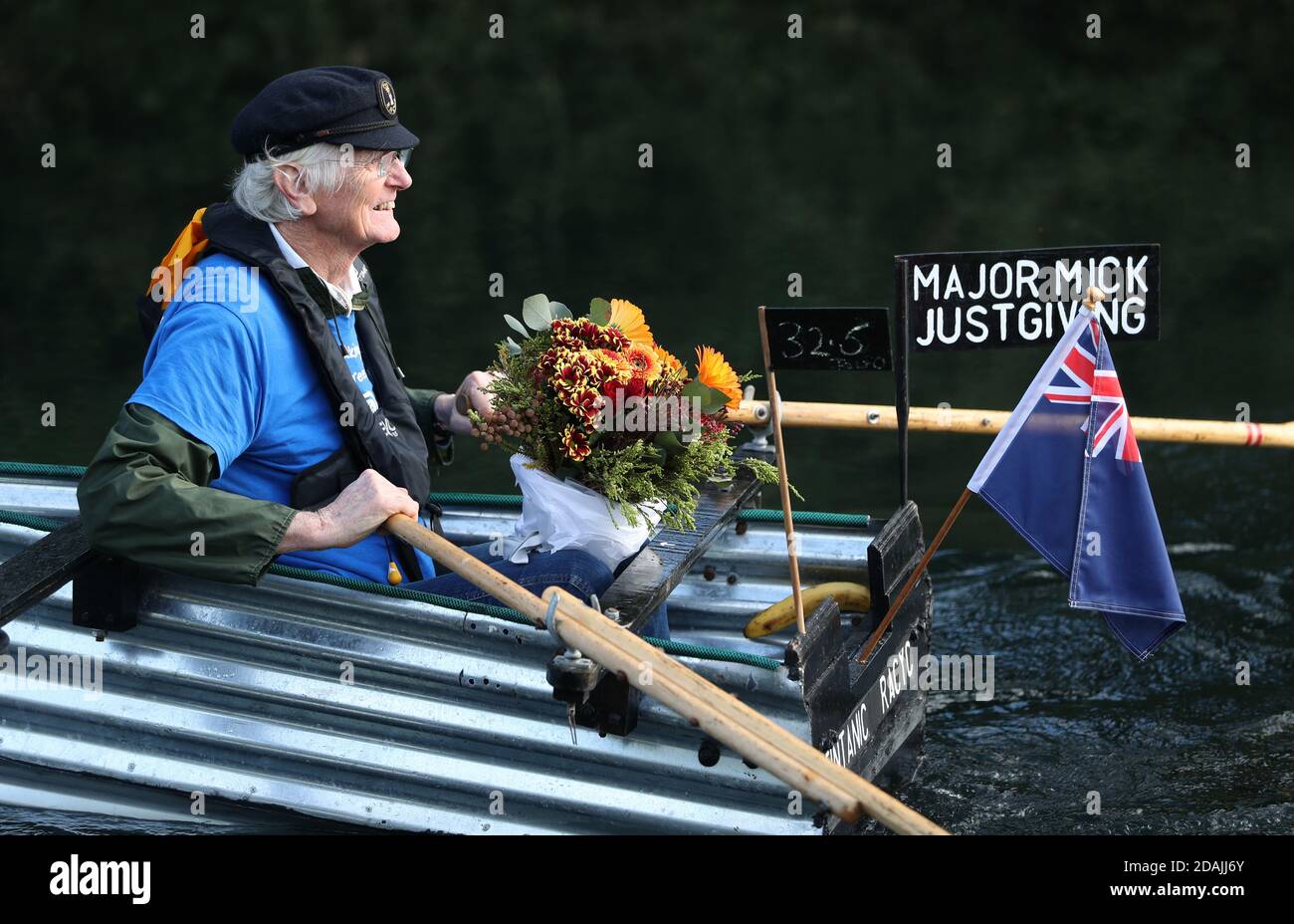 Michael Stanley, avec quelques fleurs pour sa femme Sally, devant leur mariage d'or demain, se rogne le long du canal de Chichester, West Sussex, dans son bateau fait maison Tintanic alors qu'il approche 70 miles achevé dans son défi d'aviron. Banque D'Images