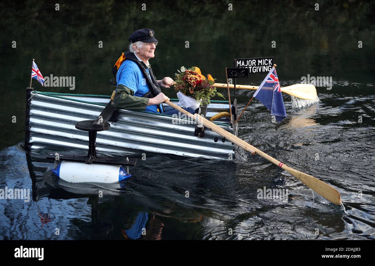 Michael Stanley, avec quelques fleurs pour sa femme Sally, devant leur mariage d'or demain, se rogne le long du canal de Chichester, West Sussex, dans son bateau fait maison Tintanic alors qu'il approche 70 miles achevé dans son défi d'aviron. Banque D'Images