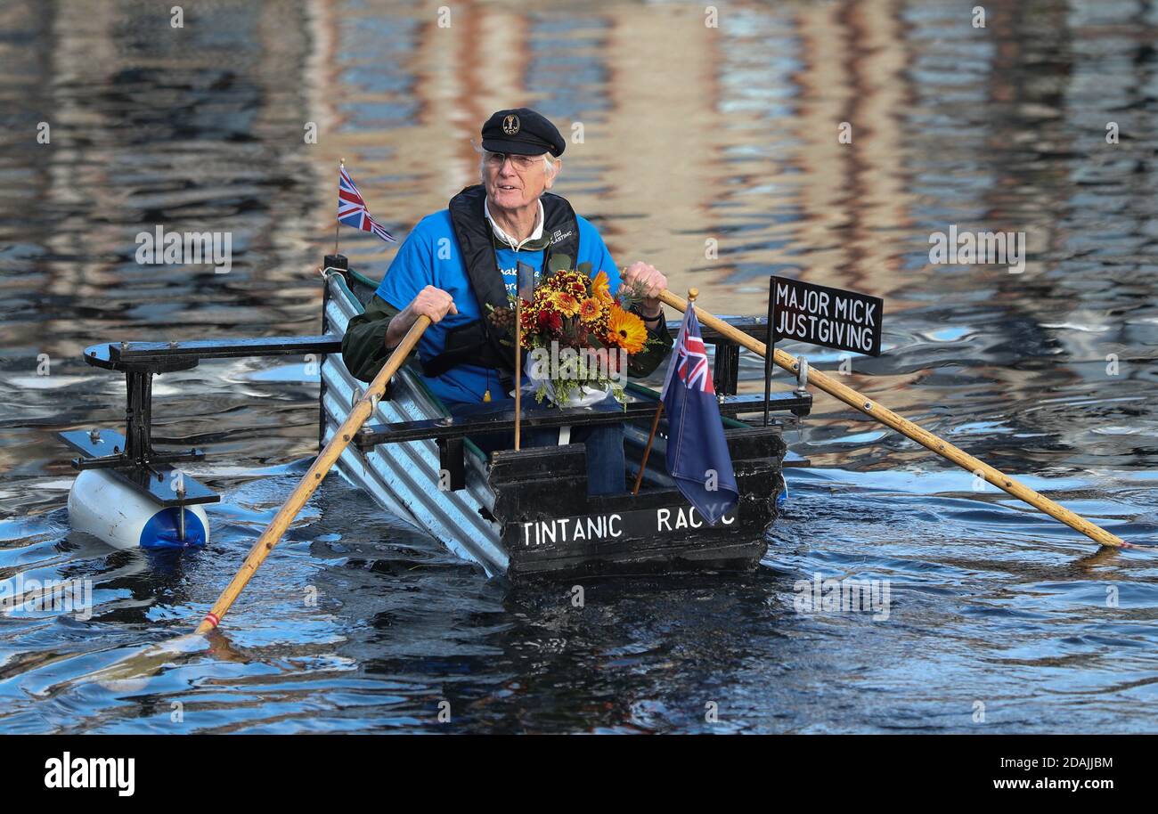 Michael Stanley, avec quelques fleurs pour sa femme Sally, devant leur mariage d'or demain, se rogne le long du canal de Chichester, West Sussex, dans son bateau fait maison Tintanic alors qu'il approche 70 miles achevé dans son défi d'aviron. Banque D'Images