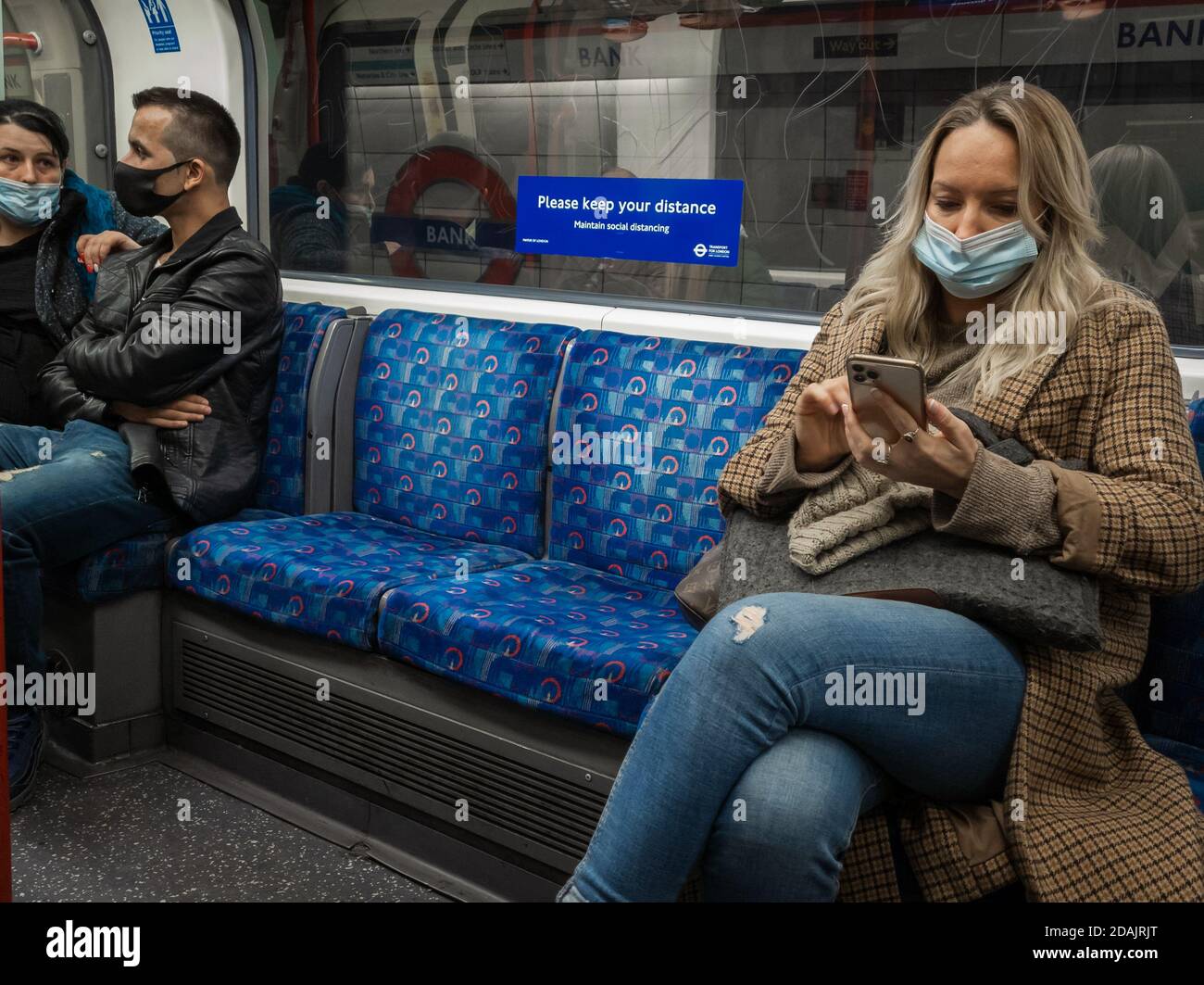 Passagers du métro de Londres portant un masque facial et une distance sociale. Banque D'Images