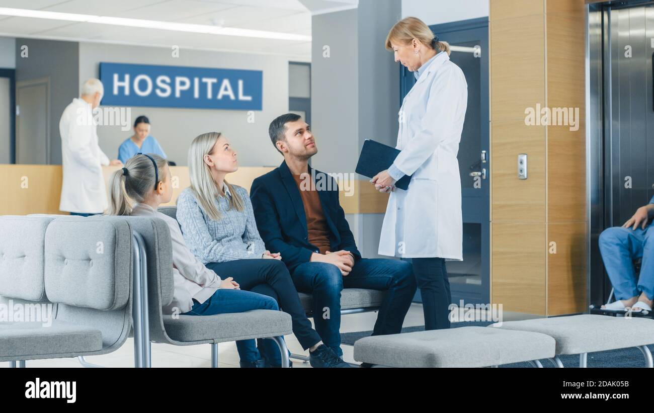 À l'hôpital, la jeune famille de père, la mère et la petite fille attendent les résultats des tests dans le hall, bientôt ils reçoivent de leur bonne nouvelle Banque D'Images