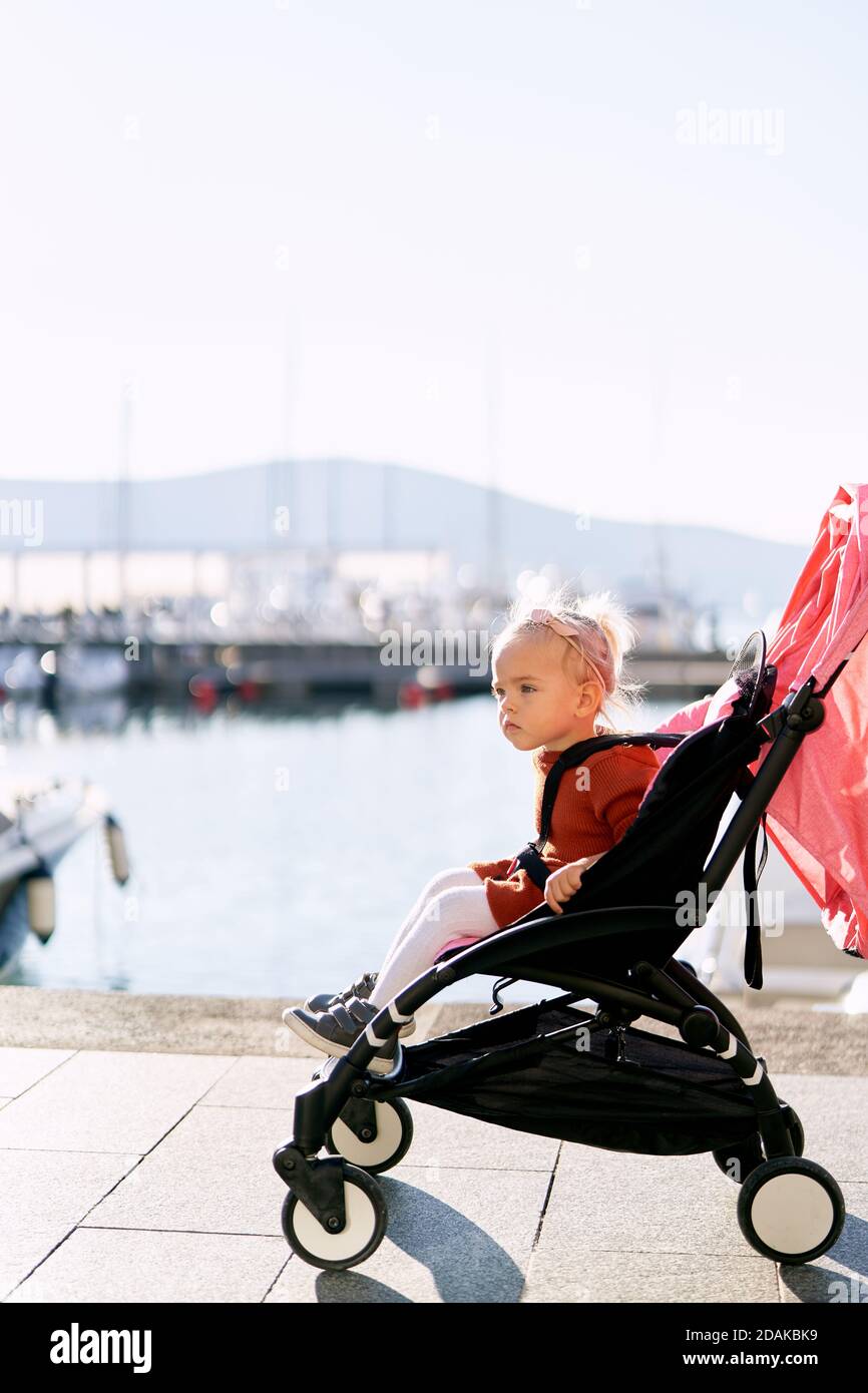 Petite Fille Dans Une Robe En Terre Cuite Et Collants Blancs Est Assis Dans Une Poussette Rose Sur Un Quai Photo Stock Alamy Petite Fille Dans Une Robe En Terre Cuite Et Collants Blancs Est Assis Dans Une Poussette Rose Sur Un Quai Photo Stock Alamy