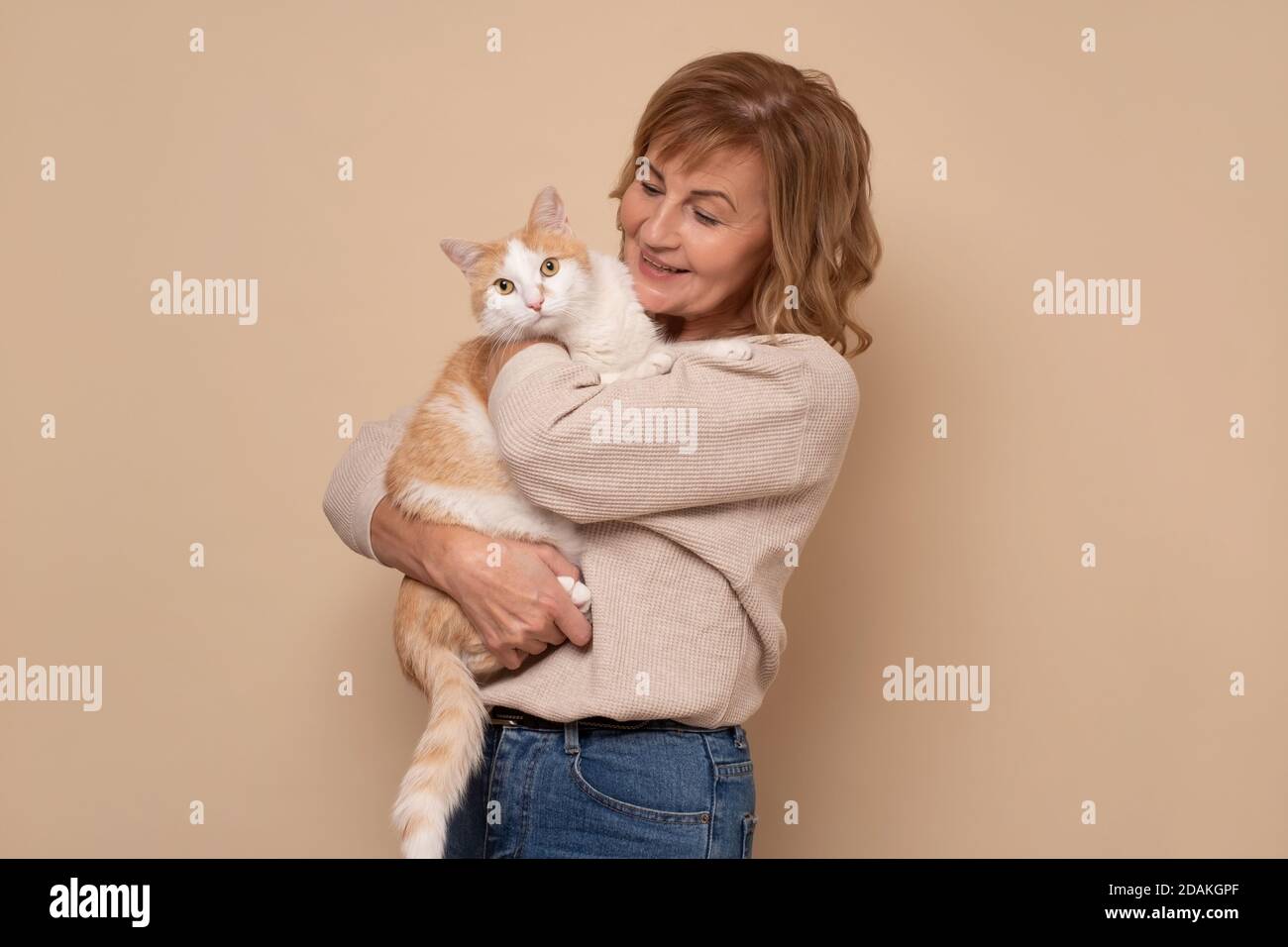 Femme caucasienne mature avec des lunettes tenant un chat Banque D'Images