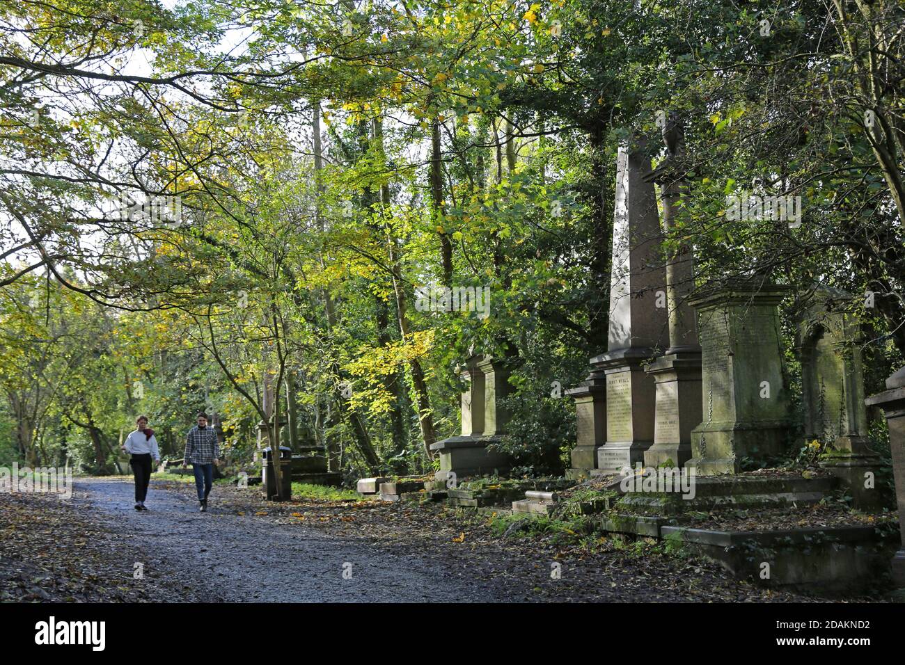 Une promenade en couple dans le cimetière Nunhead, au sud de Londres, au Royaume-Uni. Un impressionnant cimetière victorien maintenant sauvage et surcultivé, mais populaire auprès des populations locales. Banque D'Images