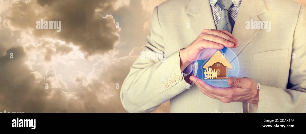Concept d'assurance. Assurance immobilière. Un agent d'assurance tient une sphère de protection avec une photo d'une maison Banque D'Images