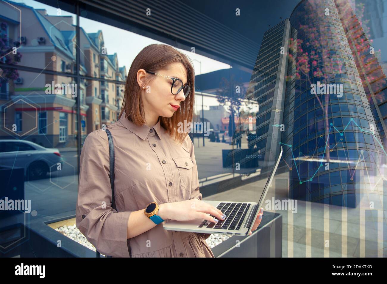 Femme d'affaires avec ordinateur à l'arrière-plan d'un bâtiment d'entreprise moderne. Banque D'Images