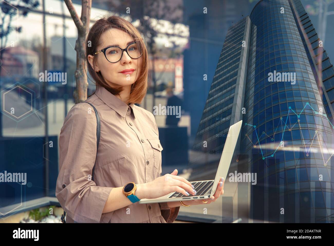 Femme d'affaires avec ordinateur à l'arrière-plan d'un bâtiment d'entreprise moderne. Banque D'Images