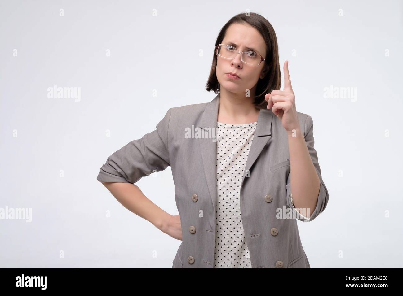 Femme d'affaires mûre d'âge moyen pointant du doigt vers le haut donnant conseils Banque D'Images