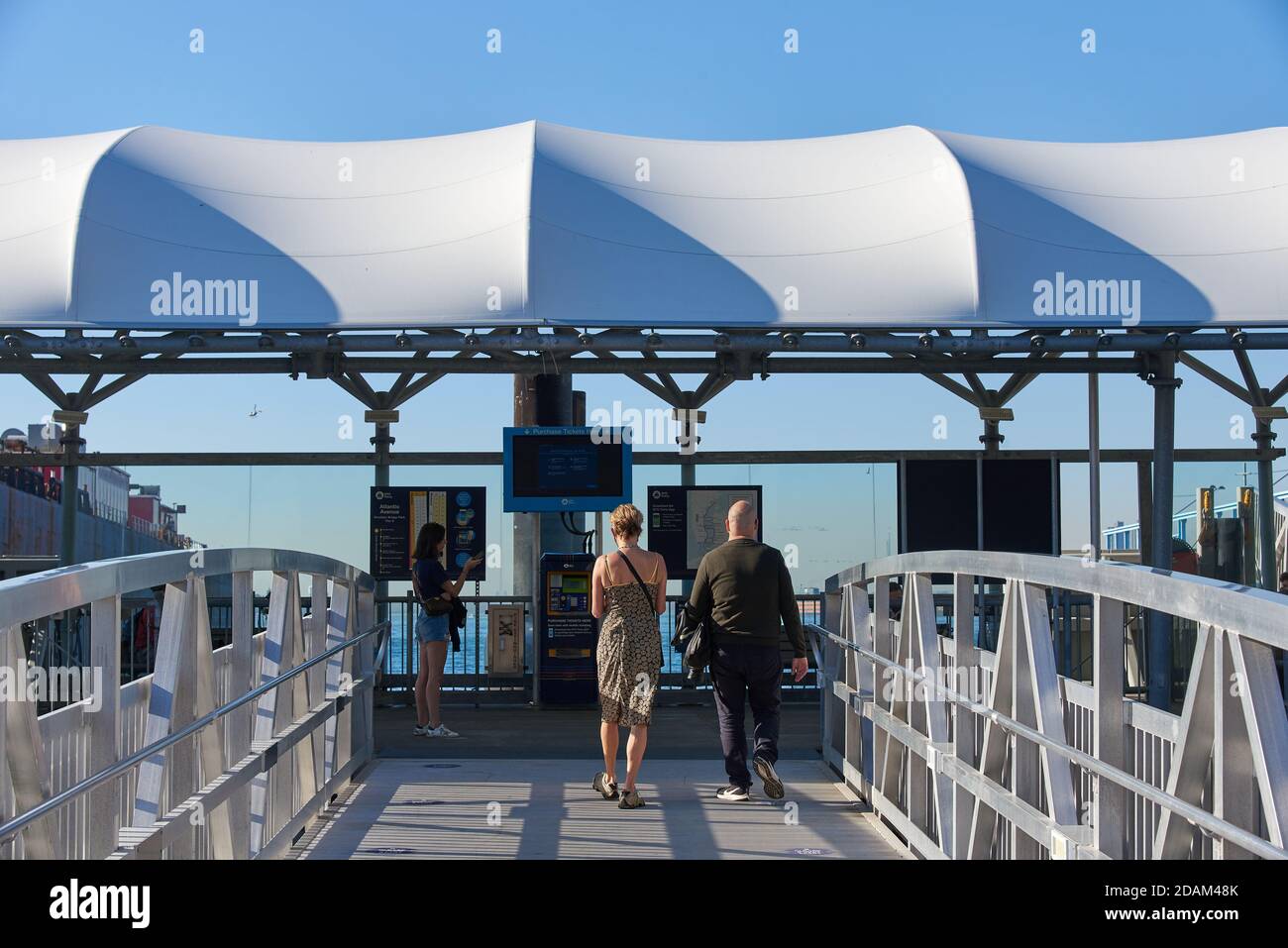 Un homme et une femme entrent à l'atterrissage du NYC Ferry à Atlantic AV à Brooklyn Bridge Park, New York. Banque D'Images