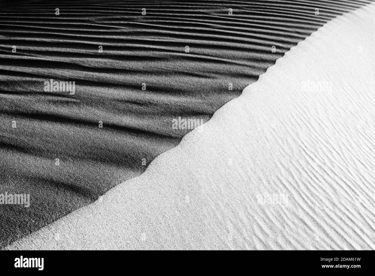 Macro-photographie de plage de sable noir et blanc. Texture de sable noir et blanc pour l'arrière-plan. Vue macro en gros plan de la surface de sable volcanique noir et W. Banque D'Images