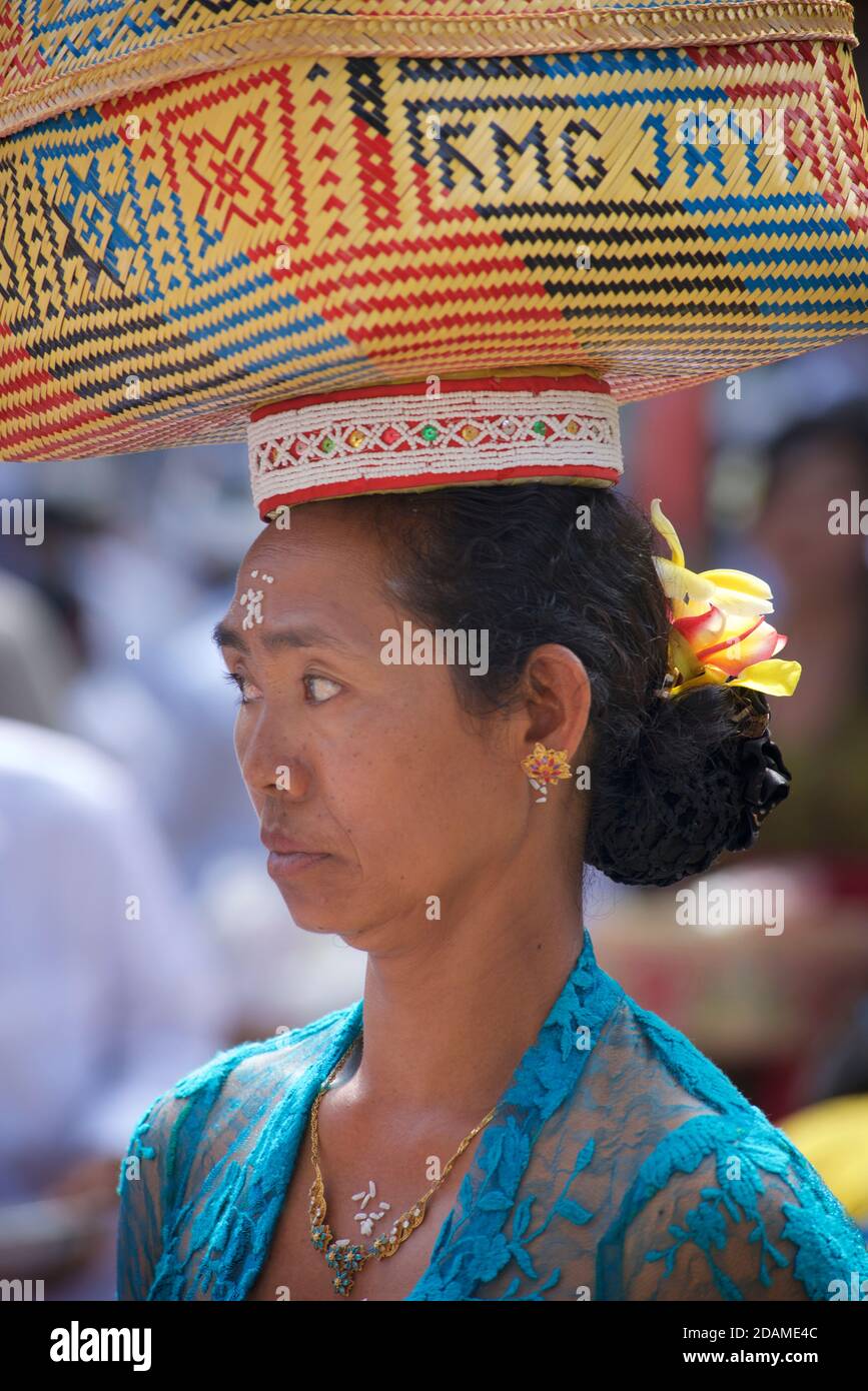 Femme balinaise en robe de cérémonie avec offrande dans un panier traditionnel, temple de Sakenan, Bali, Indonésie. Portant des offrandes au temple hindou pour le festival Galungan, Ubud, Bali, Indonésie Banque D'Images