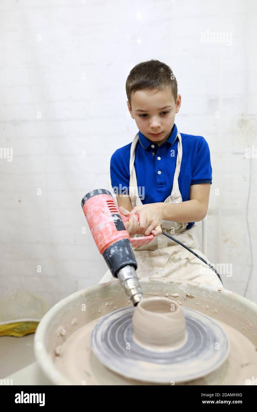 Tasse de séchage enfant sur la roue de poterie dans l'atelier Banque D'Images