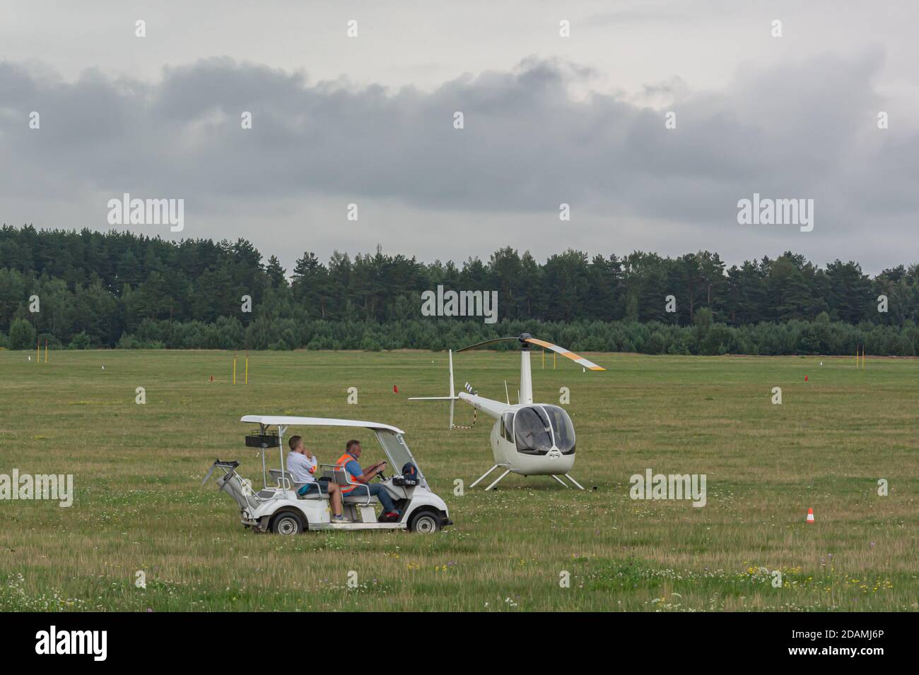 Bélarus, Minsk - 07/25/2018: Voiture électrique et hélicoptère à deux places sur le champ vert de l'aérodrome. Photos Banque D'Images