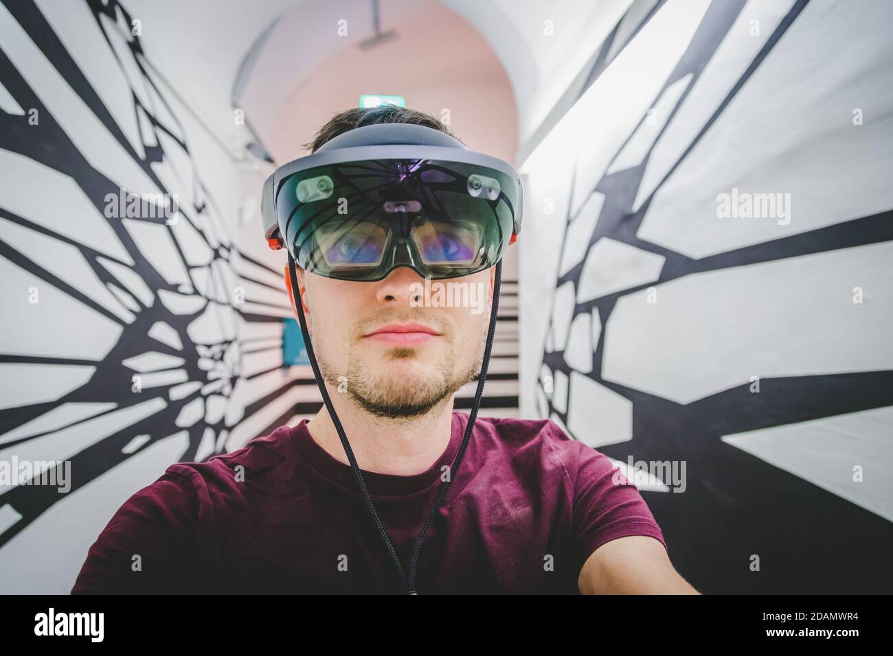 Le jeune homme utilise des lunettes de réalité virtuelle ou un casque Banque D'Images