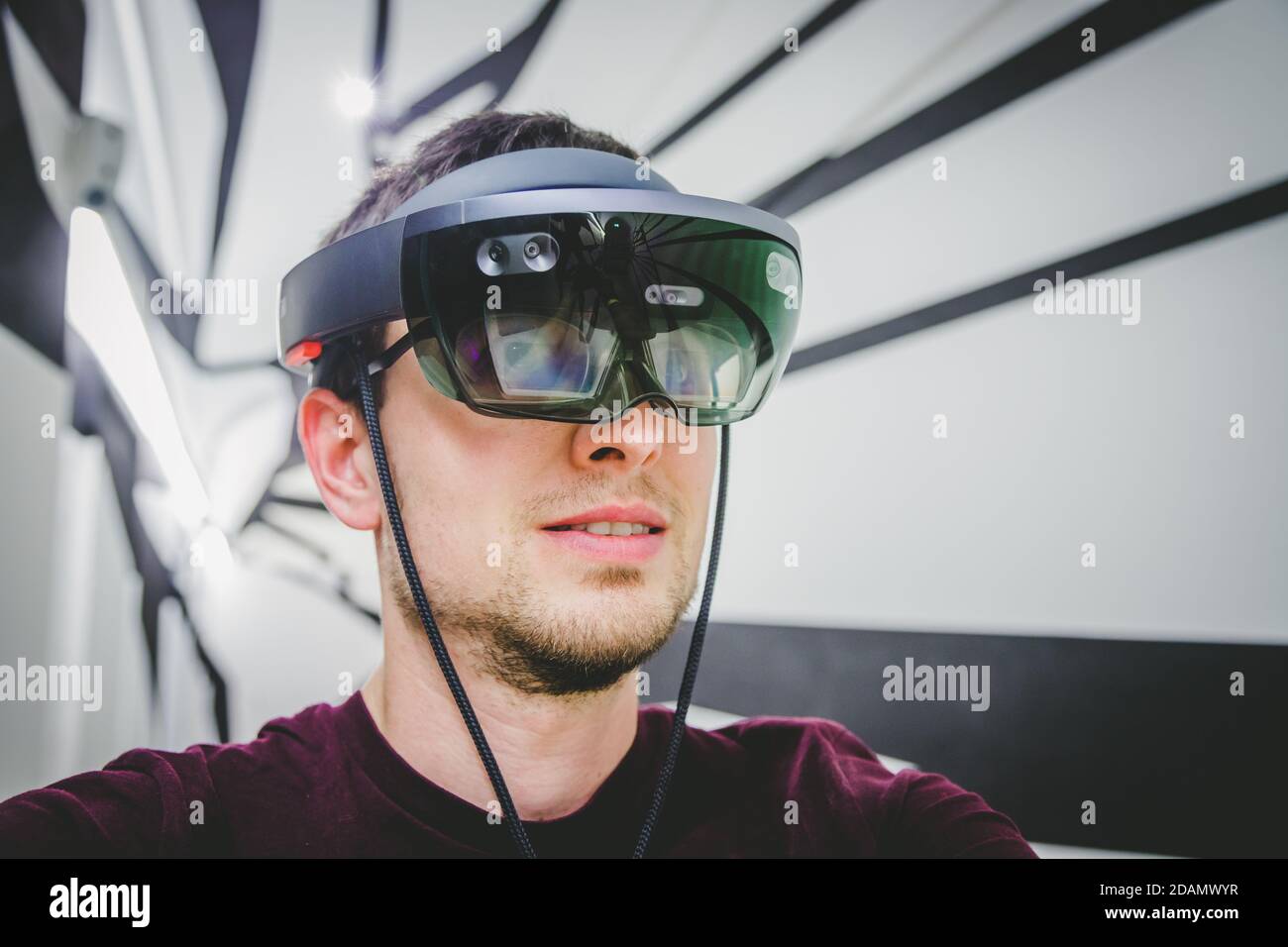 Le jeune homme utilise des lunettes de réalité virtuelle ou un casque Banque D'Images