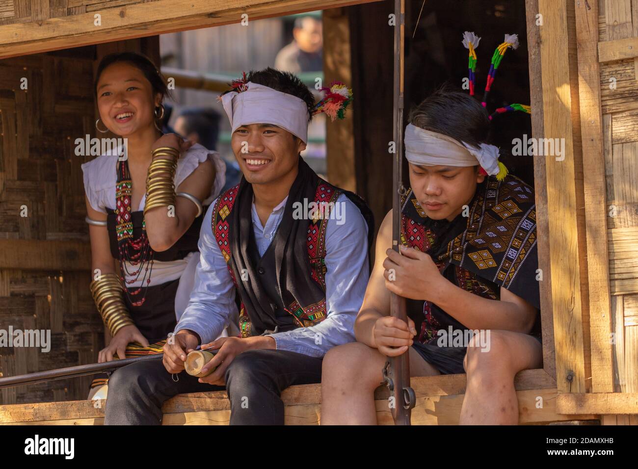 Naga garçons et fille se sitant et riant ensemble portant traditionnel Attire dans le village du patrimoine de Kisama à Nagaland Inde sur 3 Décembre 2016 Banque D'Images