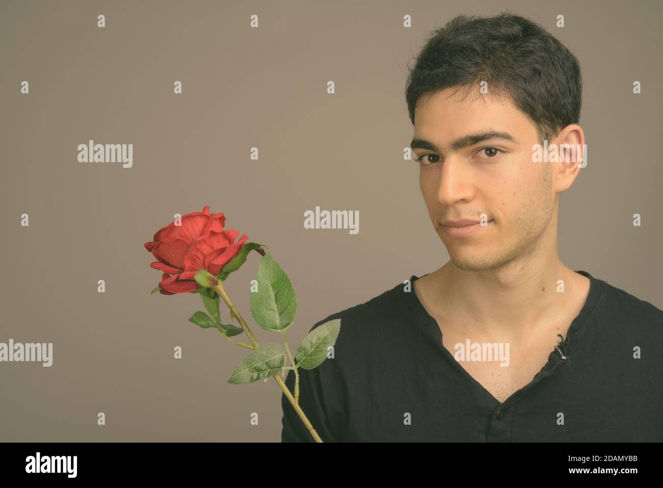 Portrait de jeune homme séduisant contre l'arrière-plan gris Banque D'Images