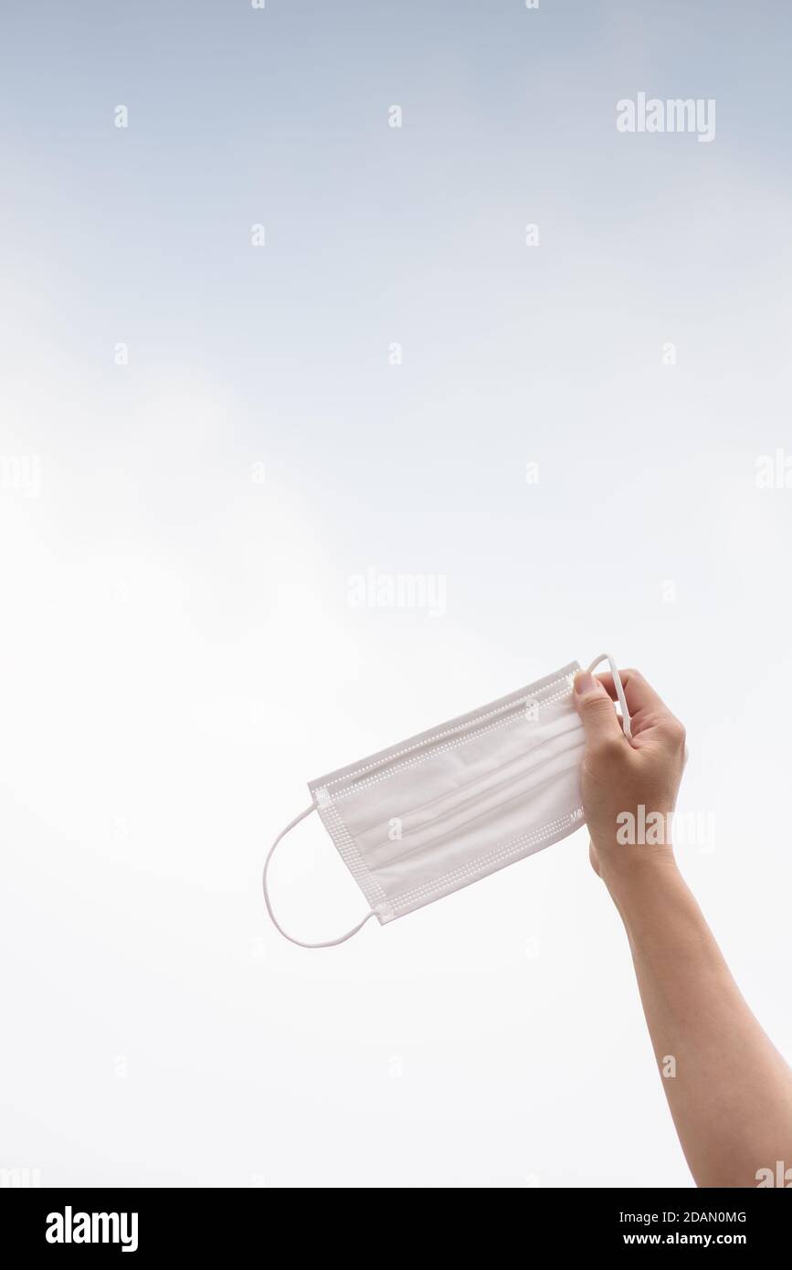 La main tenant le masque pendant la période des P2,5 et du virus corona, Covid 19 Banque D'Images