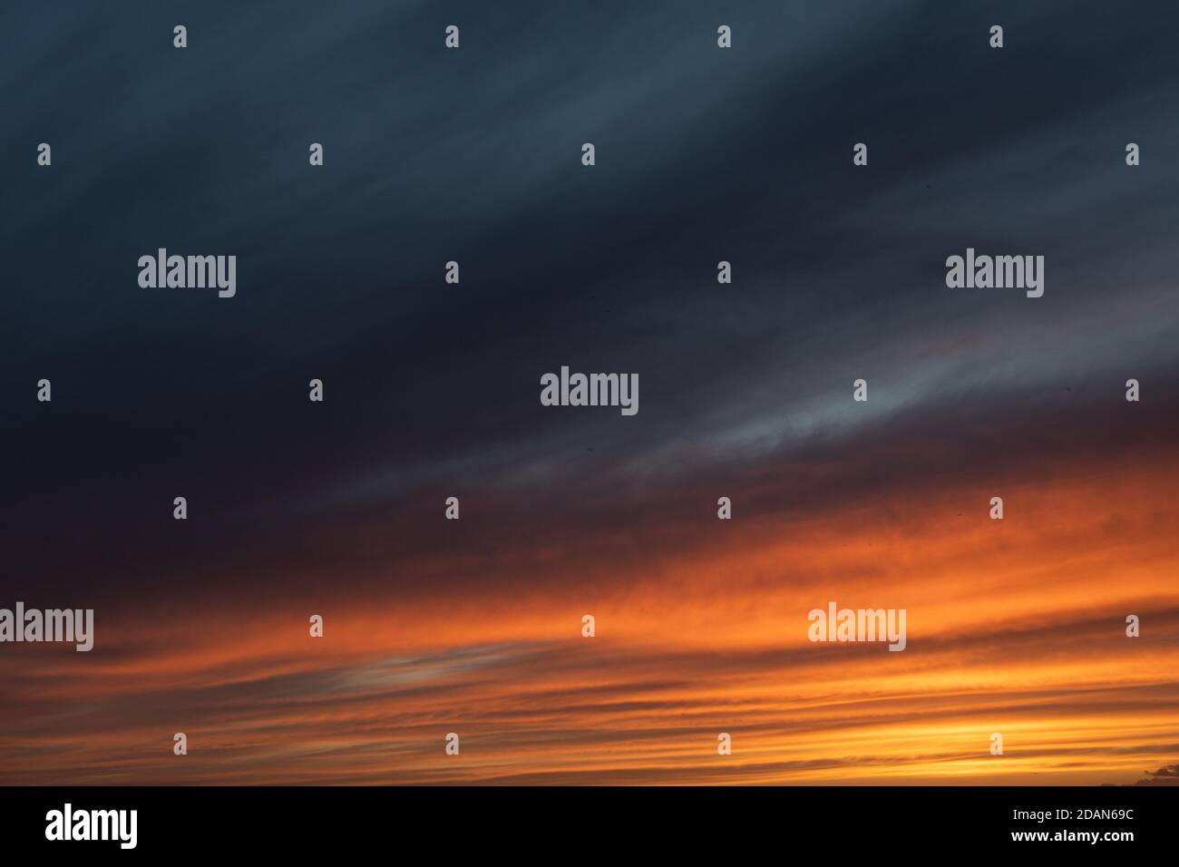 Ciel de coucher de soleil avec nuages et tons orange et bleu Banque D'Images