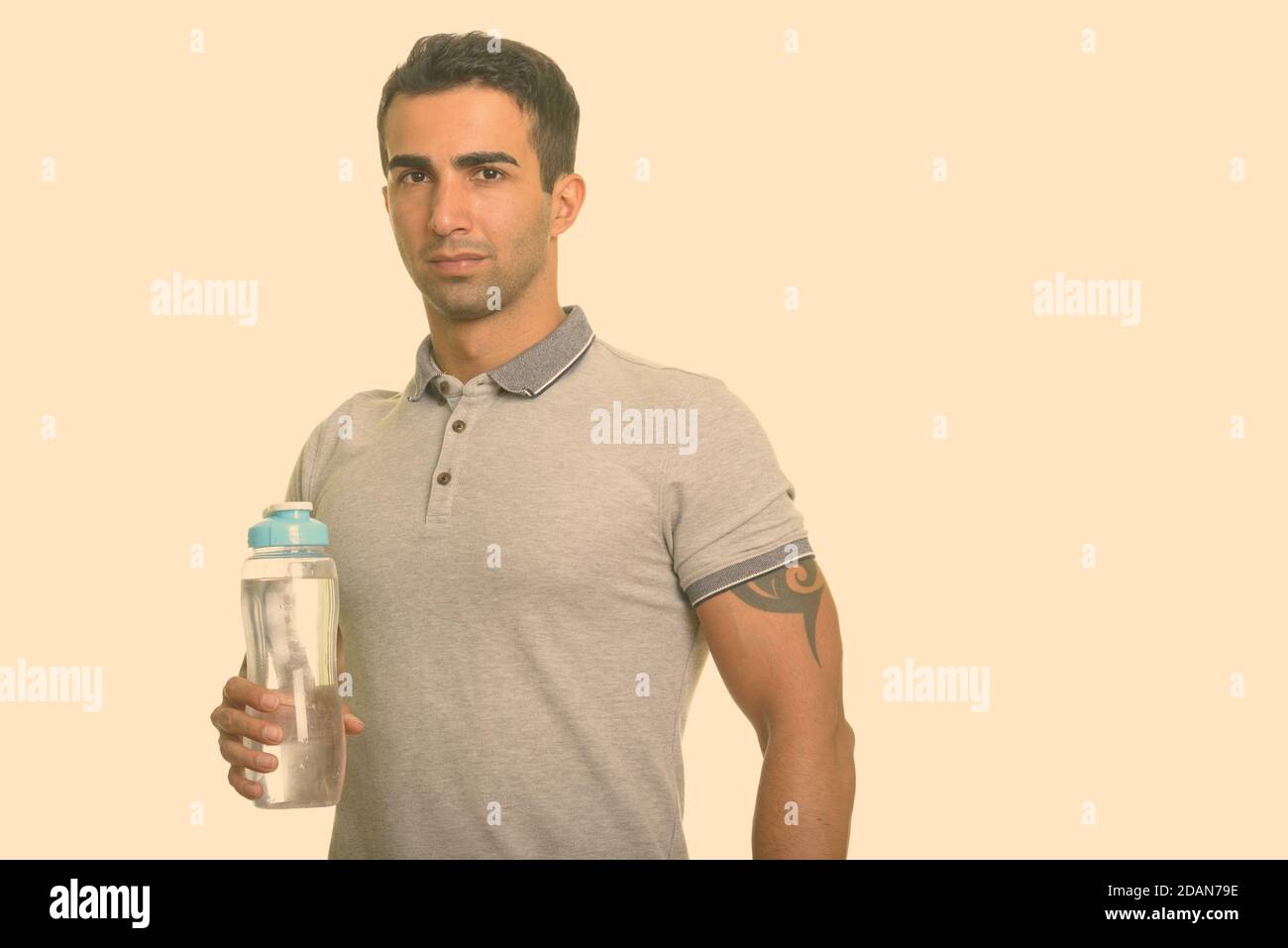 Jeune homme iranien charmant tenant une bouteille d'eau Banque D'Images