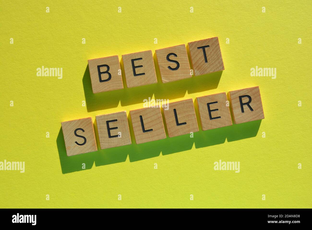 BEST Seller, mots en lettres de l'alphabet de bois isolés sur fond jaune vif Banque D'Images