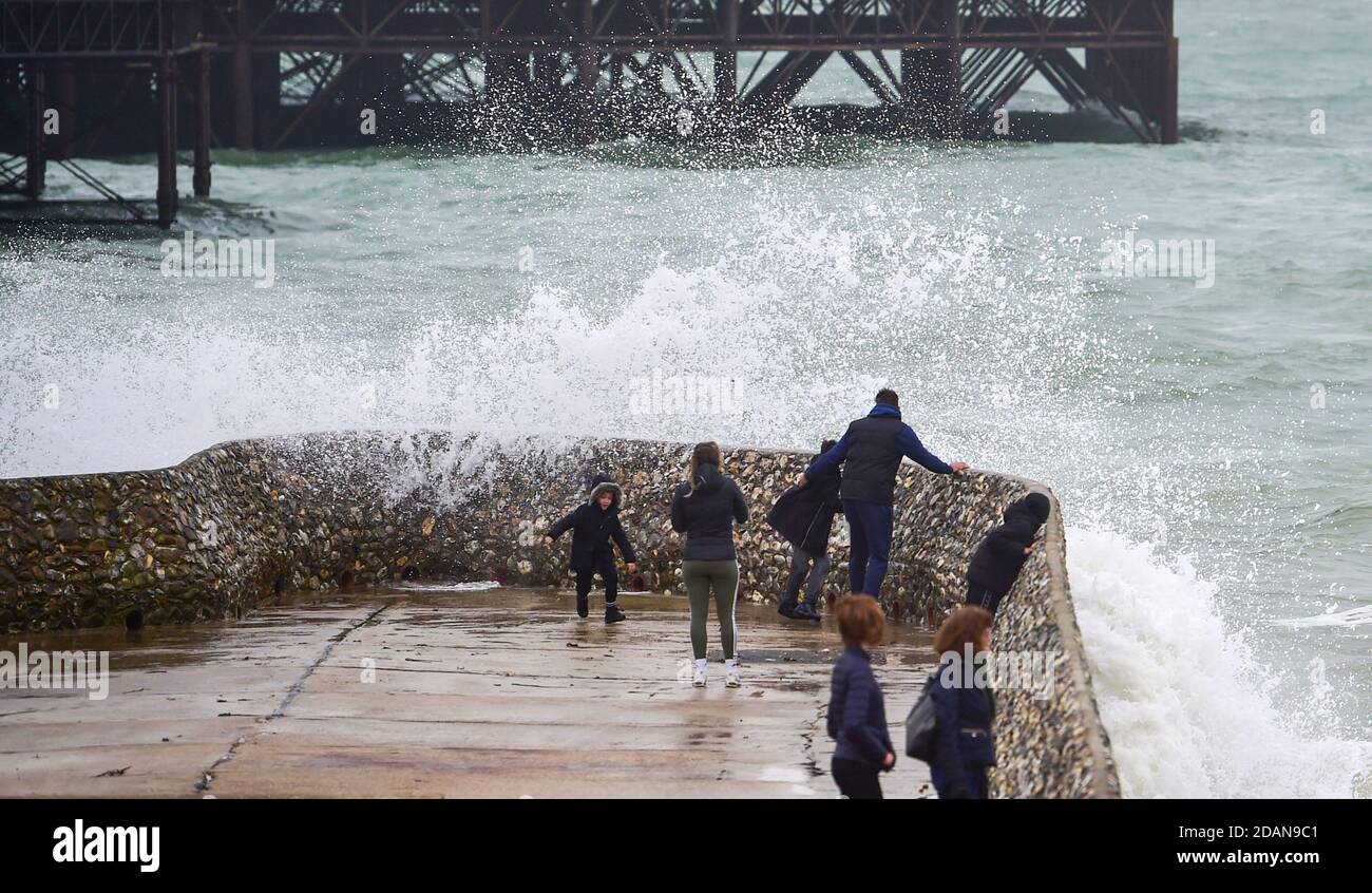 Brighton UK 14 novembre 2020 - les vagues se brisent au-dessus de Brighton front de mer Albion grin et les visiteurs se prélasser sur une journée venteuse le long de la côte sud : Credit Simon Dack / Alay Live News Banque D'Images