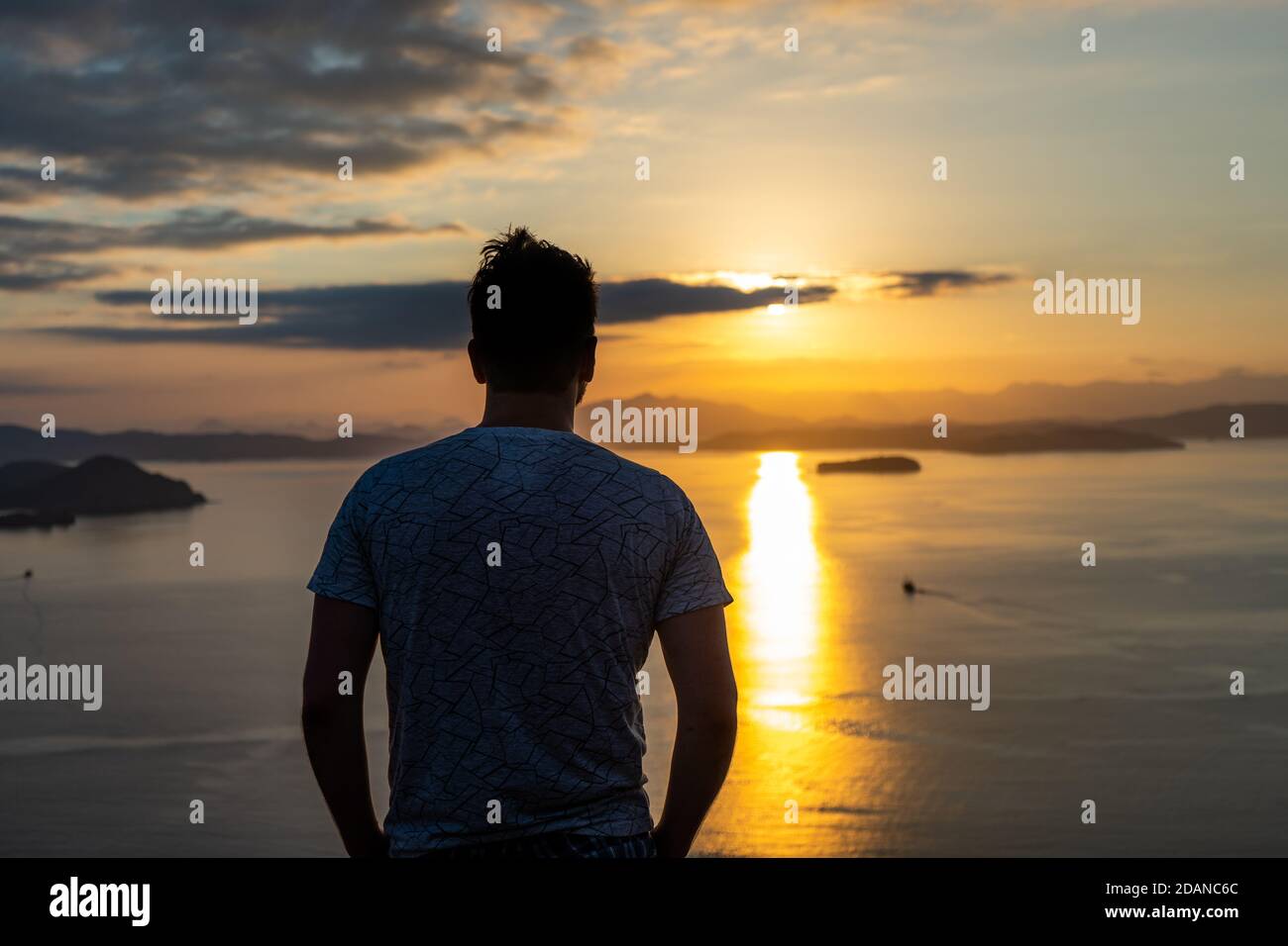 silhouette d'homme debout sur la plage au coucher du soleil Banque D'Images