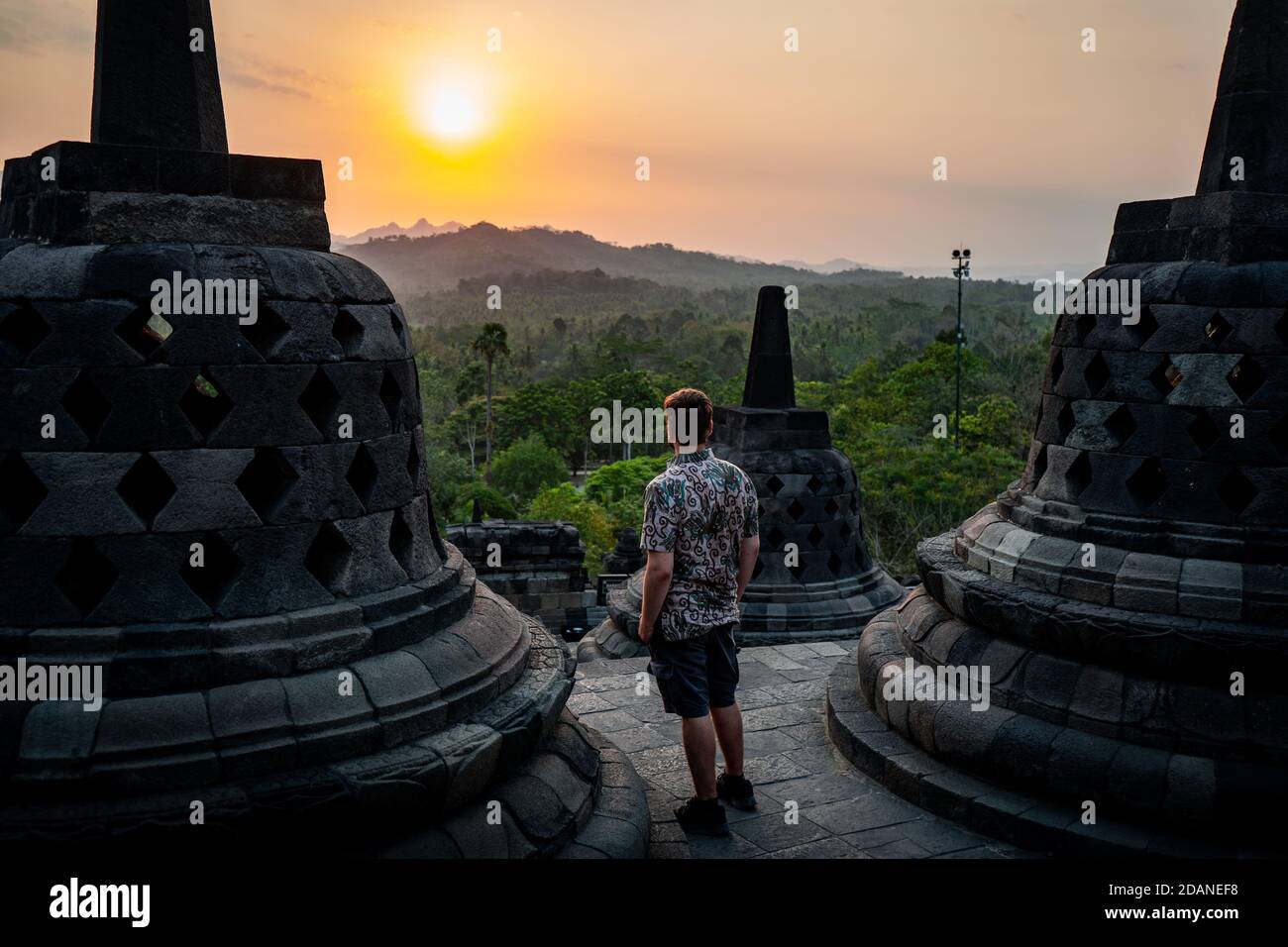 homme regardant le coucher du soleil à borobudur indonésie Banque D'Images