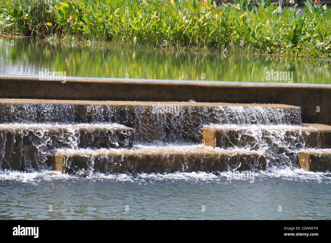 Fonction d'eau artificielle créée par l'eau en cascade sur de grandes marches en pierre. Banque D'Images