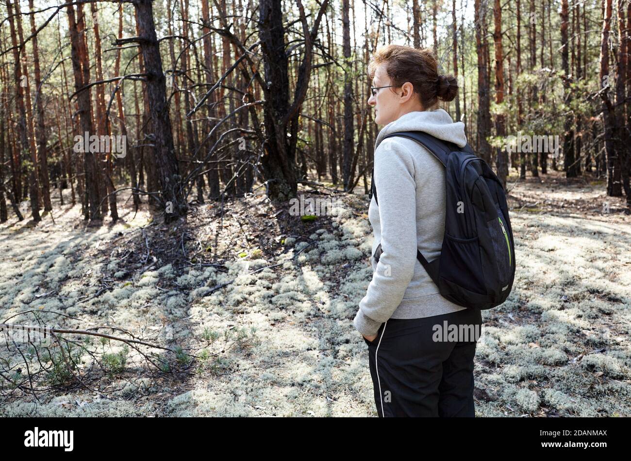 Femme de randonnée avec sac à dos sur le chemin dans la forêt d'automne. Randonnée et aventure Banque D'Images