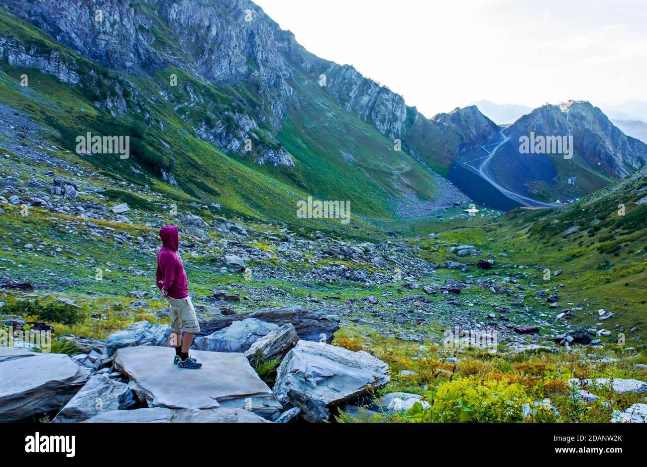 jeune homme du côté qui regarde la vallée de la montagne. Aibga crête, Voyage seul, trekking dans les montagnes, paysage Banque D'Images