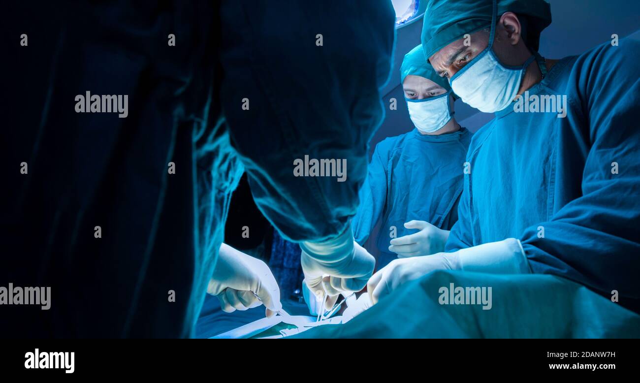 groupe de médecins chirurgicaux professionnels concentré chirurgie chirurgicale un patient dans la salle d'opération de l'hôpital. concept médical et de soins de santé. Banque D'Images