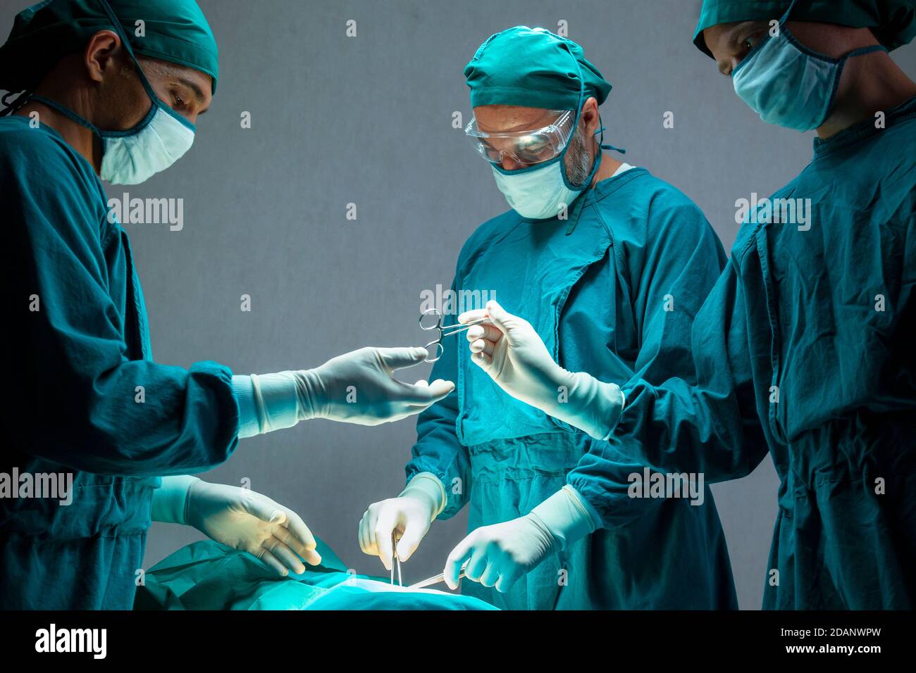groupe de médecins chirurgicaux professionnels concentré chirurgie chirurgicale un patient dans la salle d'opération de l'hôpital. concept médical et de soins de santé. Banque D'Images