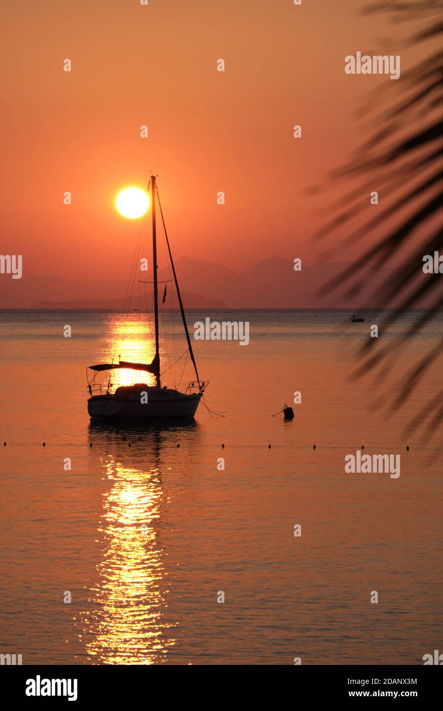 Silhouette de yacht dans la mer Égée au-dessus du soleil et des montagnes, Turquie Banque D'Images