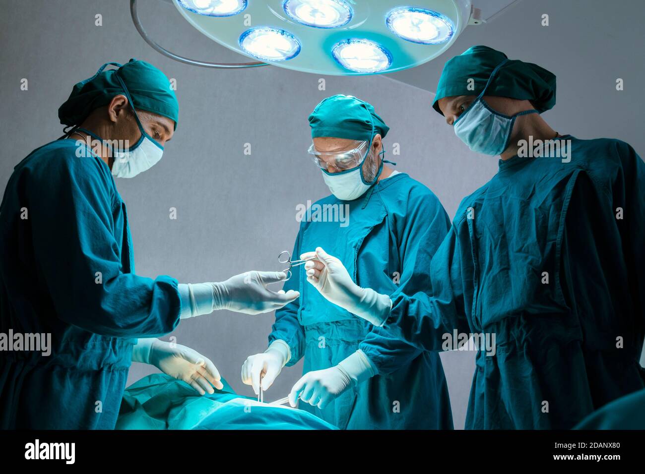 groupe de médecins chirurgicaux professionnels concentré chirurgie chirurgicale un patient dans la salle d'opération de l'hôpital. concept médical et de soins de santé. Banque D'Images