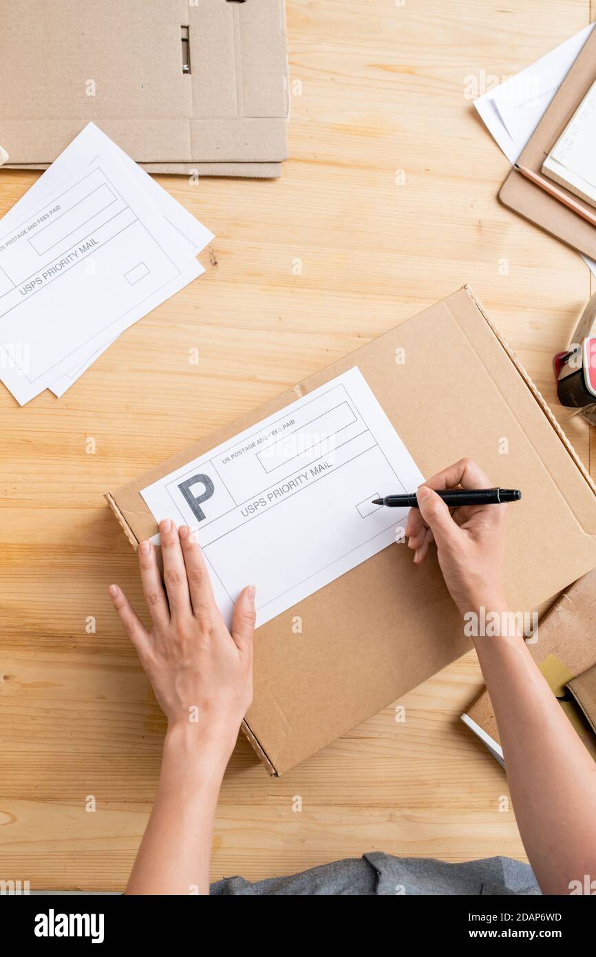 Aperçu des mains de la femme responsable de l'écriture de boutique en ligne adresse inférieure sur la boîte Banque D'Images