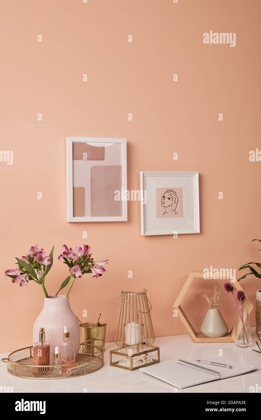 Lieu de travail de designer d'intérieur par mur rose avec deux photos dans les images par tableau Banque D'Images