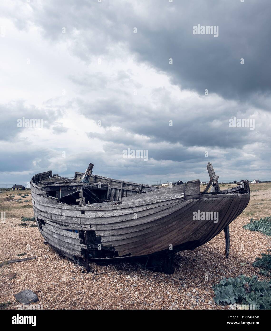 Un bateau abandonné cassé sur le paysage difficile de Dungeness, Kent. Banque D'Images