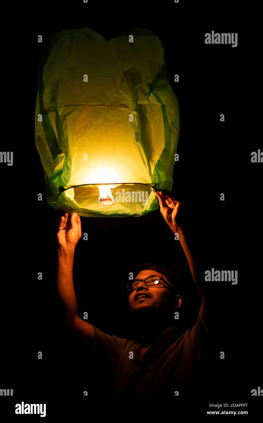 Un Indien d'âge moyen volant lanterne de ciel pendant diwali festival Banque D'Images