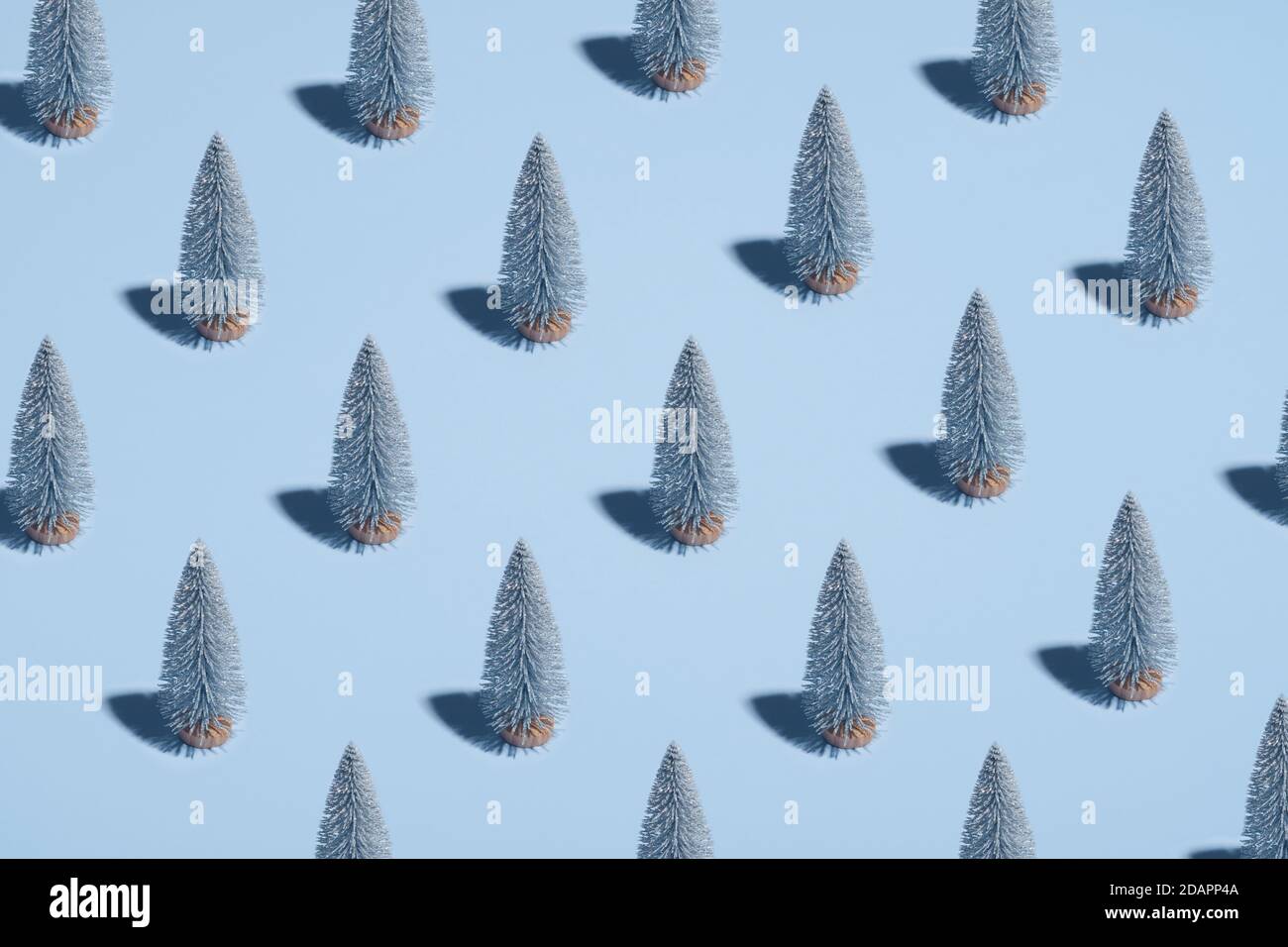 Motif d'arbres de Noël argentés sur fond bleu pastel. Style minimaliste. Concept de Noël ou de nouvel an. Banque D'Images