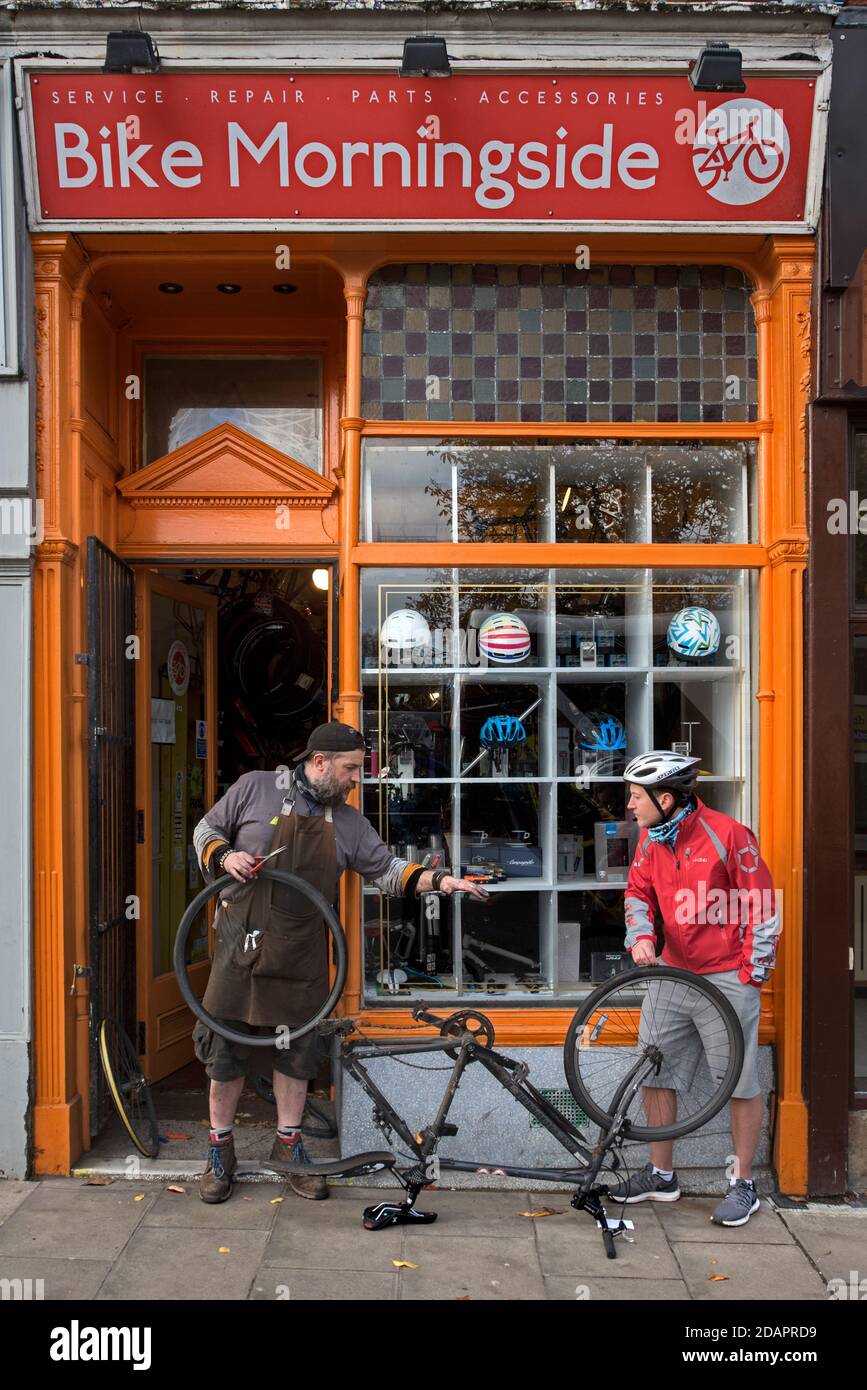 Cycliste qui obtient des conseils lors de la réparation d'une crevaison à l'extérieur du vélo Morningside Banque D'Images