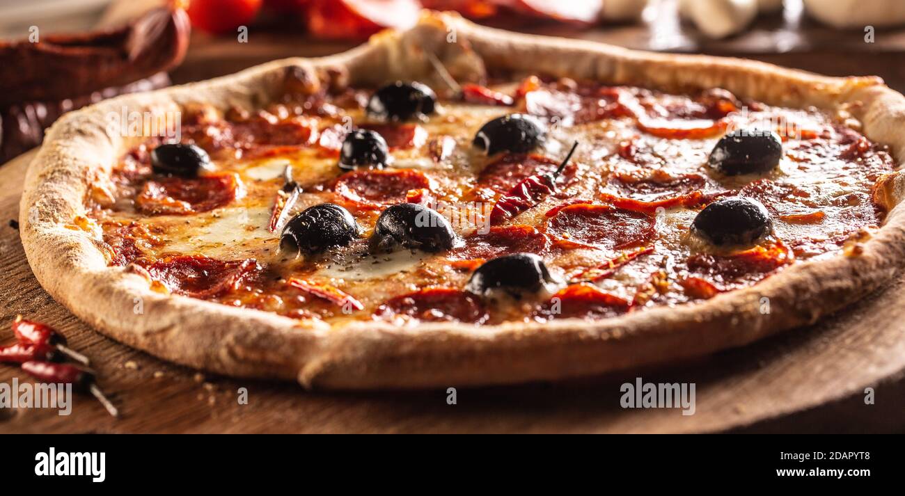 Pizza diavola repas italien traditionnel avec piment épicé de salami peperoni et olives Banque D'Images